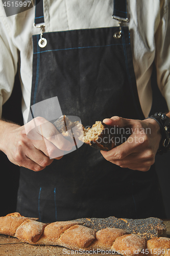 Image of halves of baguette in the hands of a baker