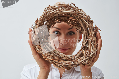 Image of Smiling girl with a wreath of twigs