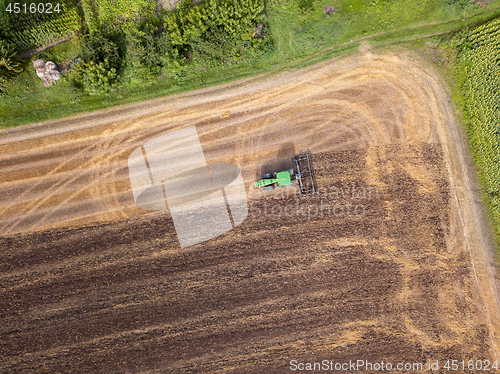 Image of Plowing the ground after harvesting on the field in the autumn time. Top view.