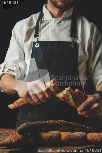 Image of Halved baguette in the hands of a baker