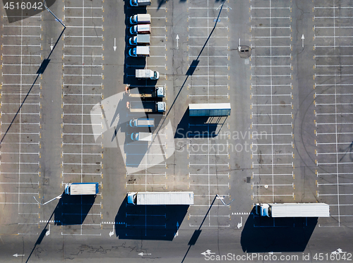 Image of Aerial view from a drone of a parking lot with a multitude of trucks on a sunny day. Top view