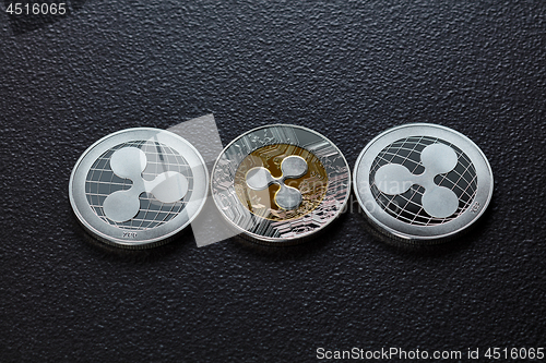 Image of Three silver ripplecoins isolated on a dark background. Cryptocurrency and blockchain trading concept. Top view