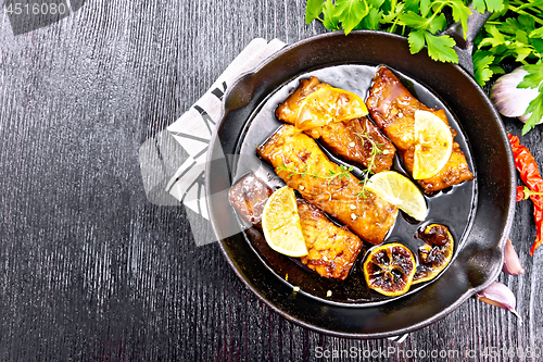 Image of Salmon with sauce in pan on board top