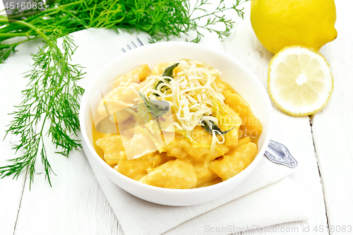 Image of Gnocchi pumpkin with lemon in bowl on wooden board