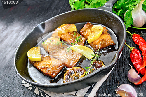 Image of Salmon with sauce in pan on black board