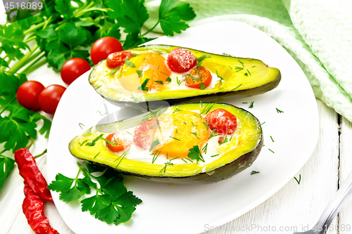 Image of Scrambled eggs with tomatoes in avocado on light board