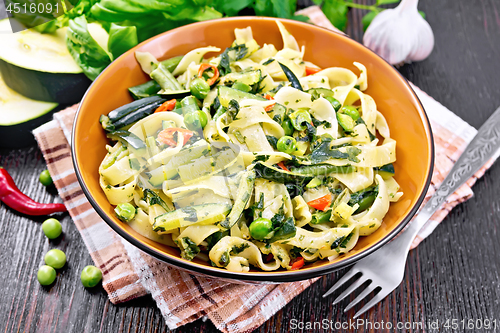 Image of Tagliatelle with green vegetables on wooden board