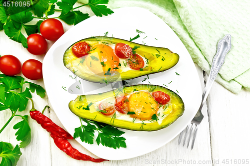 Image of Scrambled eggs with tomatoes in avocado on board top