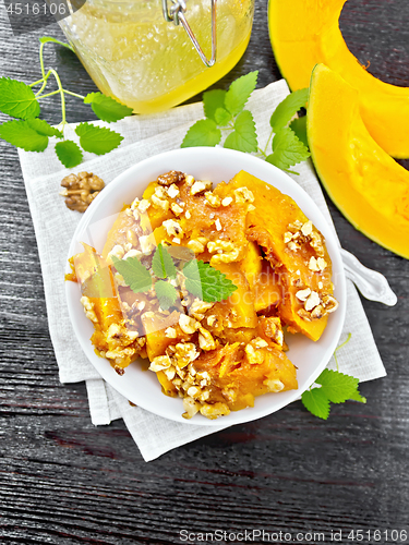 Image of Pumpkin with nuts and honey on dark board top