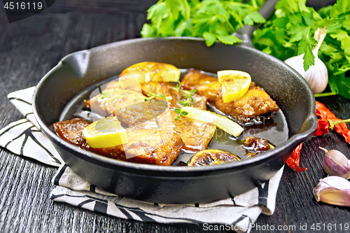 Image of Salmon with sauce in pan on black wooden board