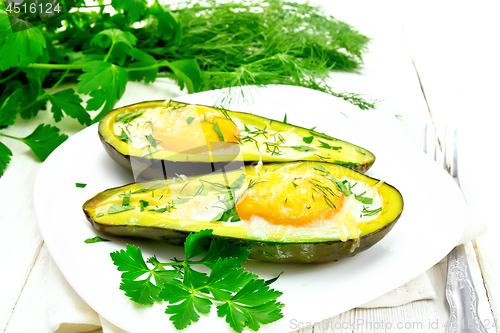 Image of Scrambled eggs in avocado on light wooden board