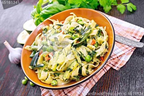 Image of Tagliatelle with green vegetables on dark board