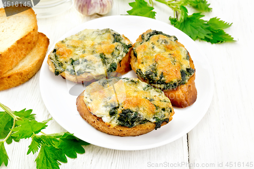 Image of Sandwich of nettle and cheese in plate on wooden board