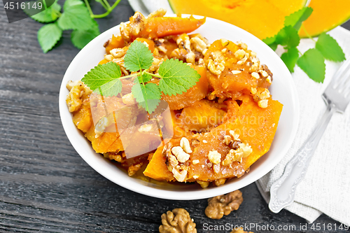 Image of Pumpkin with nuts and honey on table