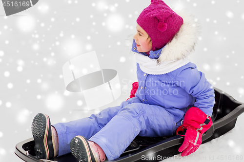 Image of happy little girl on sled outdoors in winter