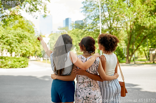 Image of young women or friends hugging at summer park