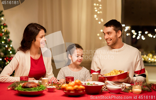 Image of happy family having christmas dinner at home