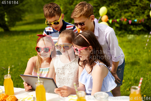 Image of happy kids with tablet pc on birthday party