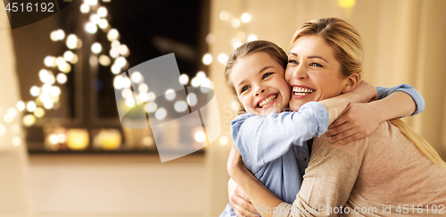 Image of happy smiling family hugging at home on christmas