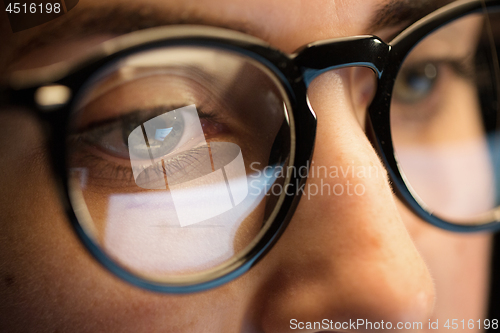 Image of close up of woman in glasses looking at screen