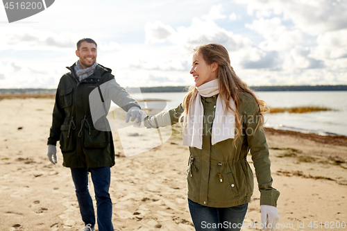 Image of couple walking along autumn beach