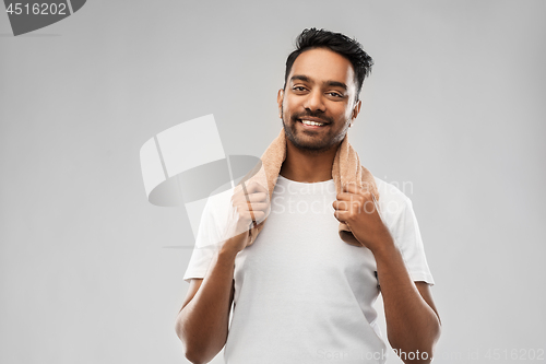 Image of smiling indian man with towel over grey background