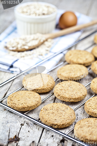 Image of Baking grid with fresh oat cookies on rustic wooden table backgr