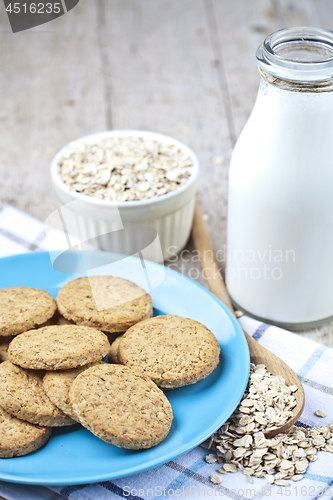 Image of Fresh baked oat cookies on blue ceramic plate on linen napkin, b