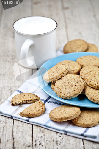 Image of Fresh baked oat cookies on blue ceramic plate on linen napkin an