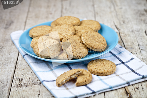 Image of Fresh baked oat cookies on blue ceramic plate on linen napkin on