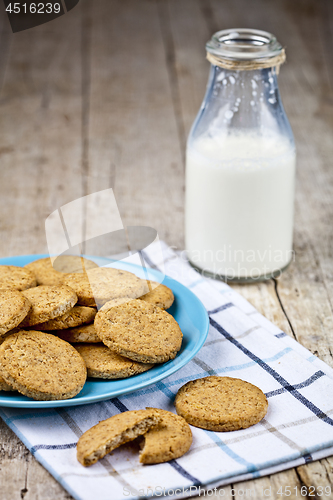 Image of Fresh baked oat cookies on blue ceramic plate on linen napkin an