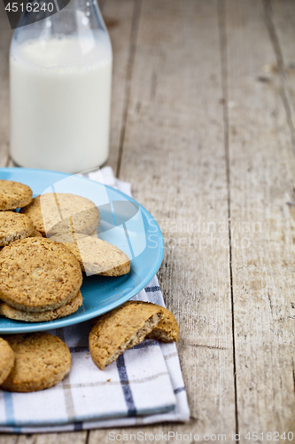 Image of Fresh baked oat cookies on blue ceramic plate on linen napkin an