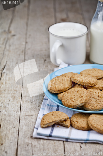 Image of Fresh baked oat cookies on blue ceramic plate on linen napkin an