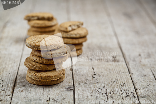 Image of Stacks of fresh baked oat cookies on rustic wooden table backgro
