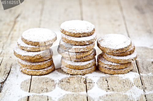 Image of Fresh oat cookies stacks with sugar powder on rustic wooden tabl