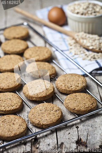 Image of Baking grid with fresh oat cookies on rustic wooden table backgr