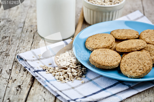 Image of Fresh baked oat cookies on blue ceramic plate on linen napkin, b
