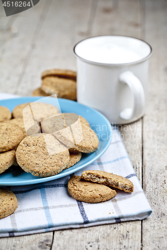 Image of Fresh baked oat cookies on blue ceramic plate on linen napkin an