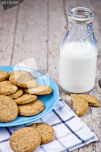 Image of Fresh baked oat cookies on blue ceramic plate on linen napkin an