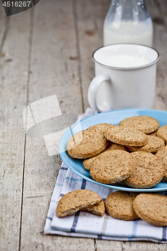 Image of Fresh baked oat cookies on blue ceramic plate on linen napkin an