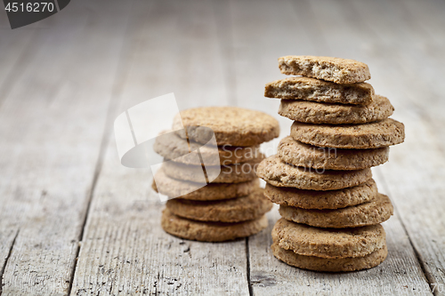 Image of Two stacks of fresh baked oat cookies on rustic wooden table bac