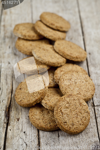 Image of Fresh baked homemade oat cookies on rustic wooden table.