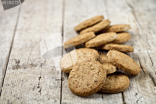 Image of Fresh baked oat cookies heap on rustic wooden table background.