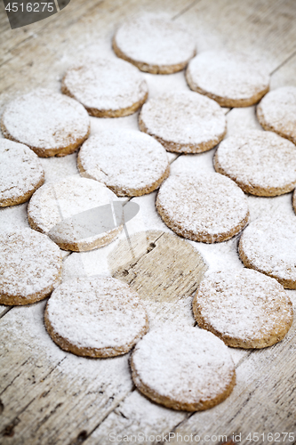 Image of Fresh baked oat cookies with sugar powder on rustic wooden table