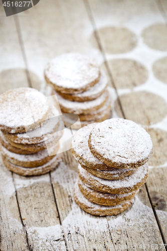 Image of Fresh oat cookies stacks with sugar powder on rustic wooden tabl