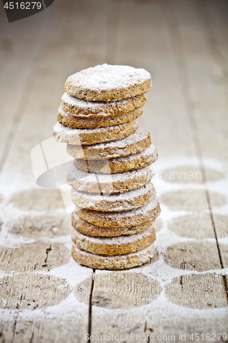 Image of Fresh oat cookies stack with sugar powder closeup on rustic wood