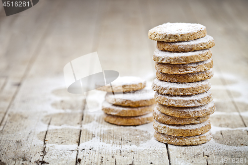 Image of Fresh oat cookies stack with sugar powder closeup on rustic wood
