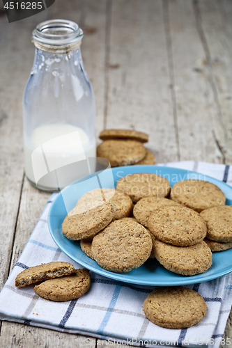 Image of Fresh baked oat cookies on blue ceramic plate on linen napkin an