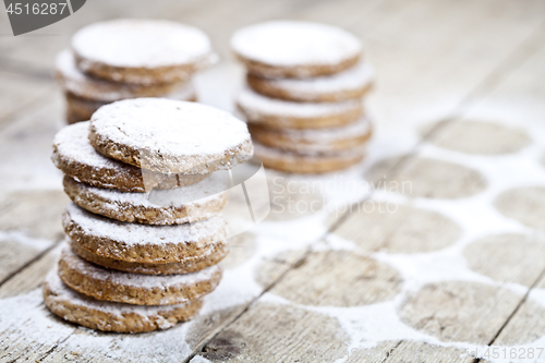 Image of Fresh baked oat cookies with sugar powder on rustic wooden table