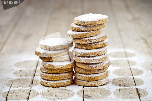 Image of Fresh oat cookies stacks with sugar powder closeup on rustic woo